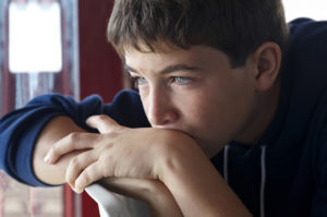 Pensive child looking through a window